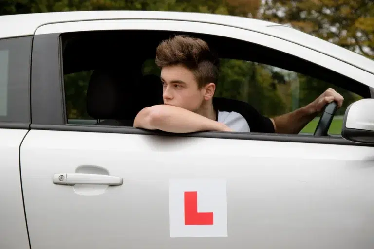 A learner driver leaning out of the window