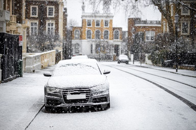 black car parked on a snowy street in London